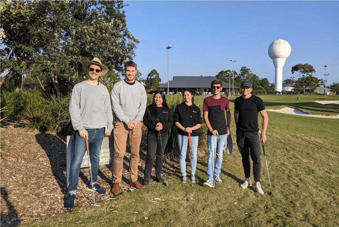 Members of the Outwrite team standing on a golf course